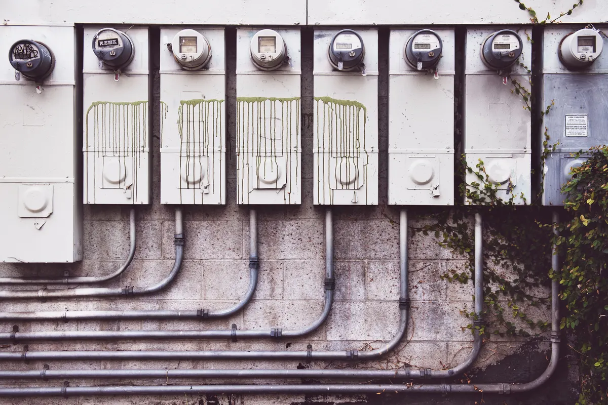 Row of outdoor electric meters and conduit on a wall, the kind of equipment inspectors check during a generator permit review
